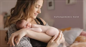 A warm, lifestyle photo of a mother gently holding her newborn baby in the "bean" position.